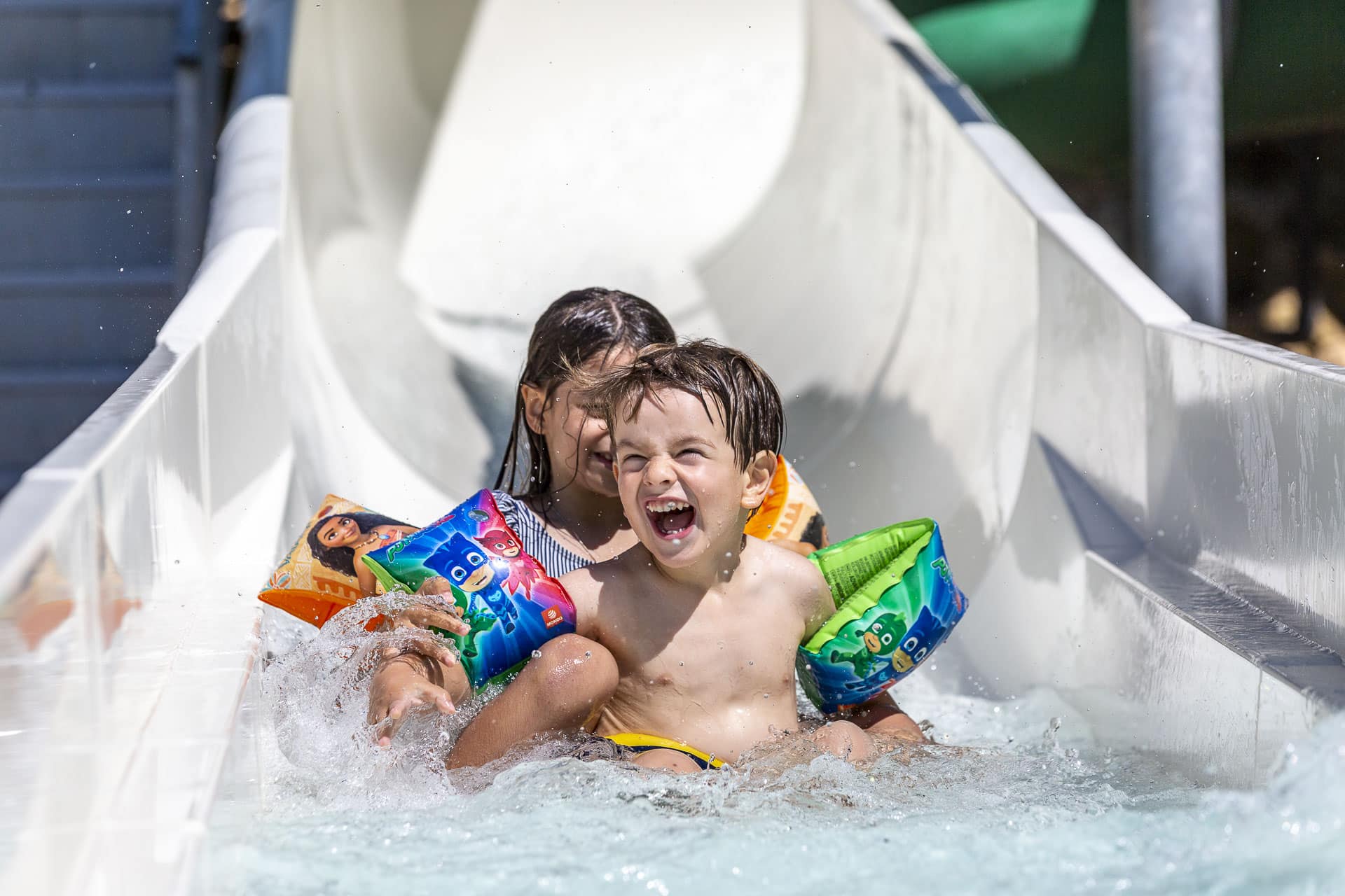 Children laughing on a water slide.