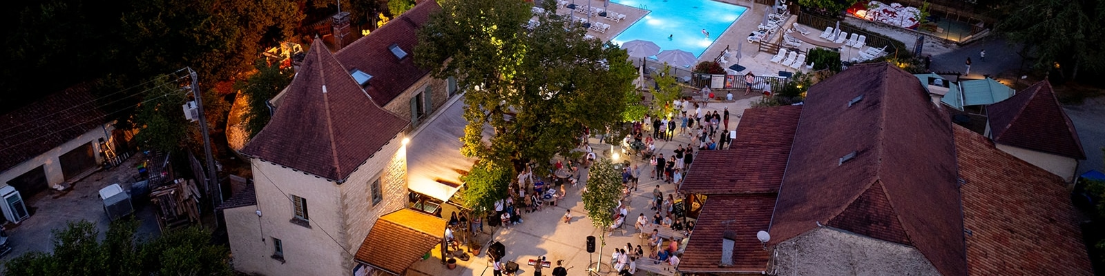Restaurant et piscine d'un camping en Dordogne vu de nuit