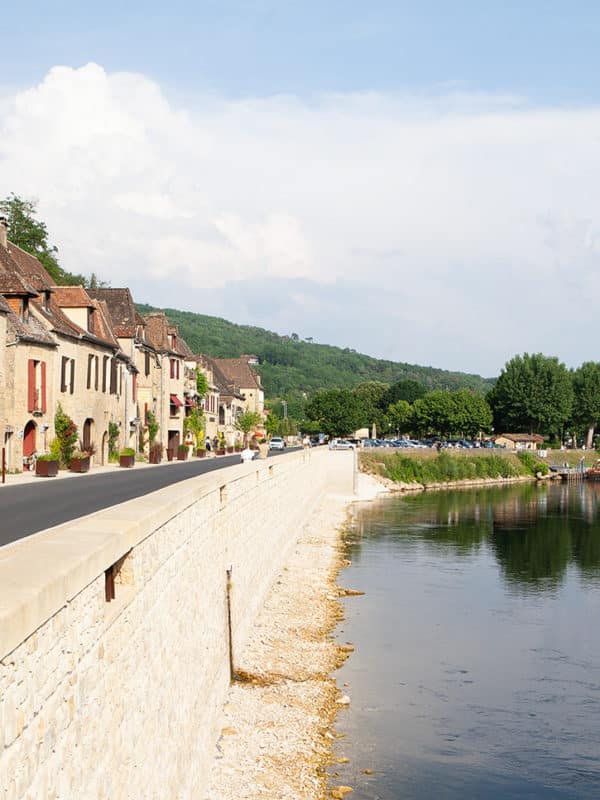 Ein mittelalterliches Dorf am Flussufer im Sommer.